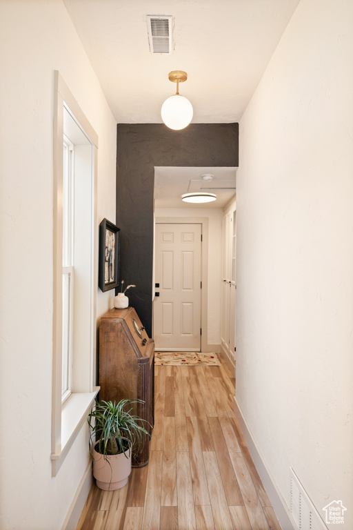 Corridor with light wood-style floors and baseboards