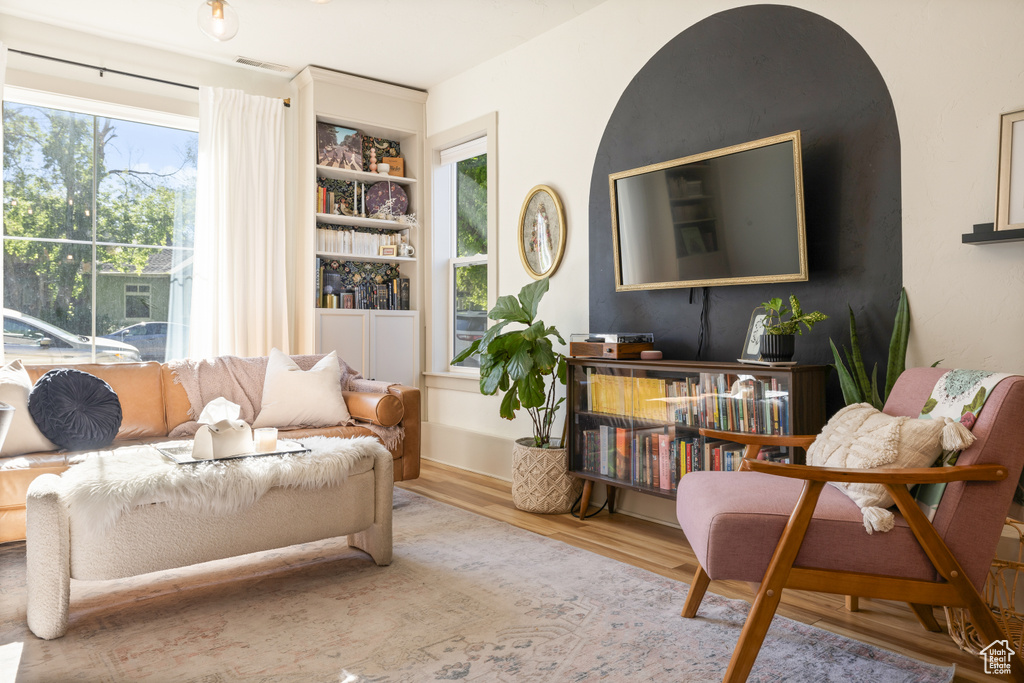 Living room featuring wood finished floors and built in shelves