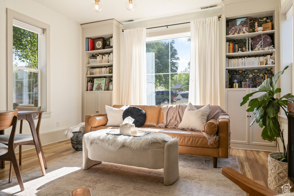 Sitting room featuring wood finished floors, healthy amount of natural light, and built in features