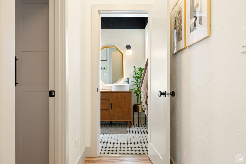 Hallway featuring a sink and baseboards