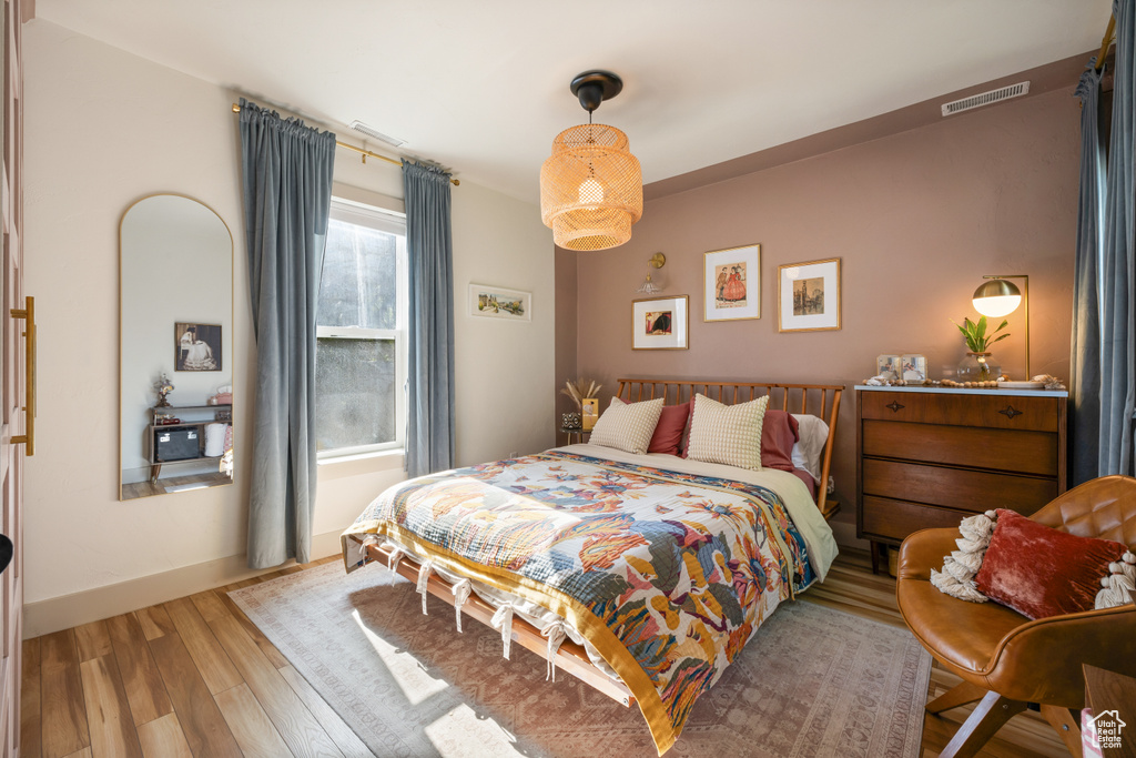 Bedroom with wood finished floors and baseboards