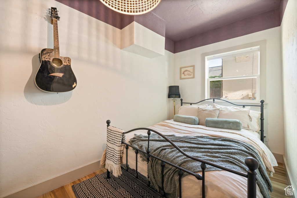 Bedroom with wood finished floors and baseboards