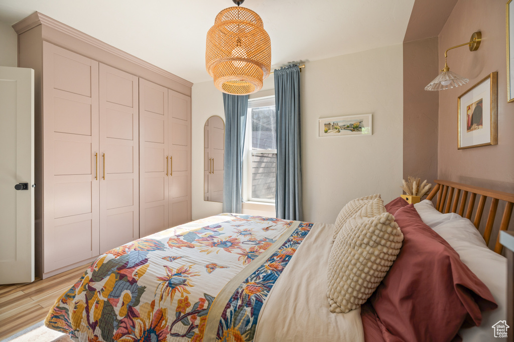Bedroom with light wood-type flooring, a closet, and arched walkways