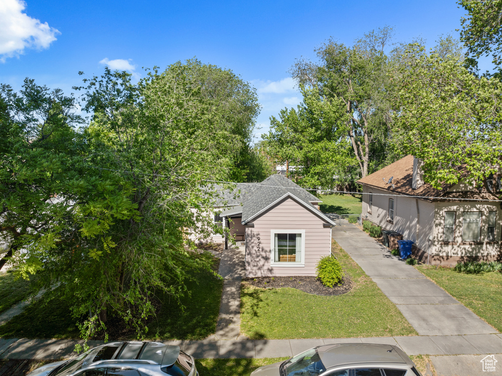 View of front of house featuring a front yard and a shingled roof