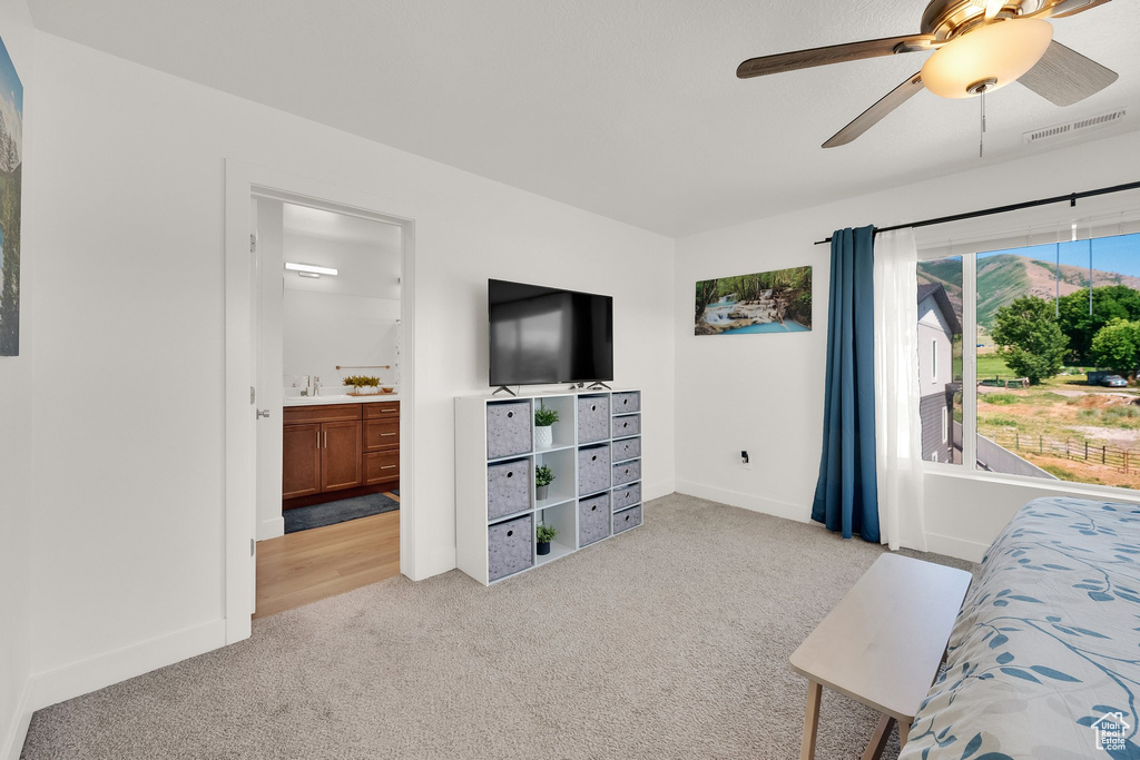 Living room with light carpet and a ceiling fan