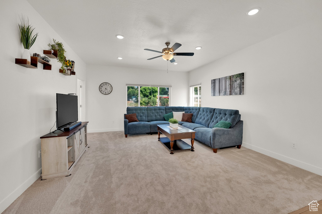 Living room featuring ceiling fan, light carpet, and recessed lighting