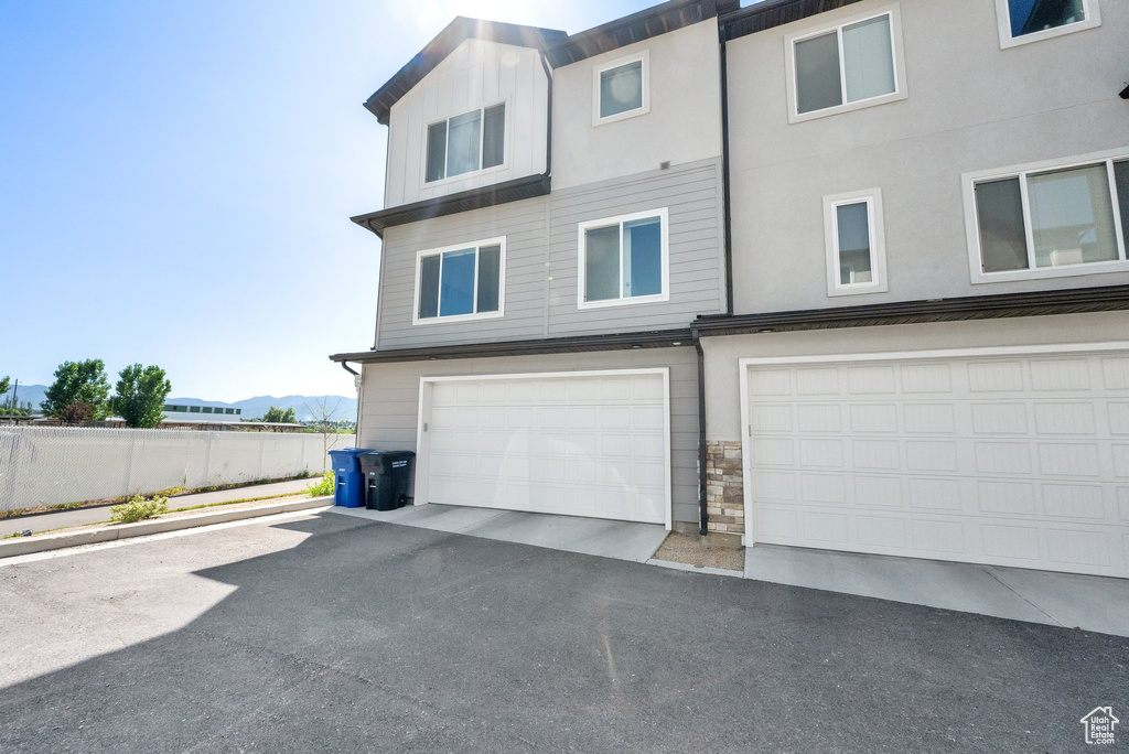 Back of property featuring stone siding, an attached garage, and a mountain view