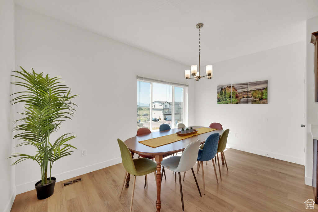 Dining area with light wood finished floors and a chandelier