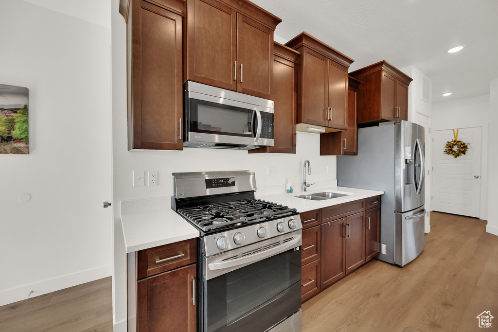 Kitchen featuring stainless steel appliances, light wood-style flooring, light countertops, and recessed lighting