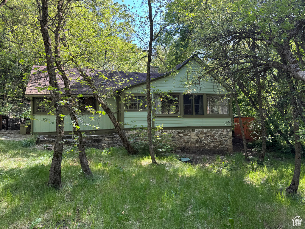 View of side of property featuring a shingled roof