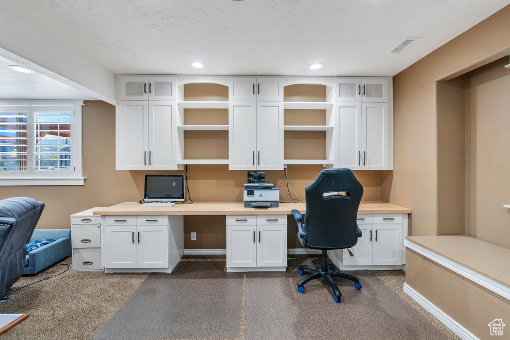Office space with built in desk and recessed lighting