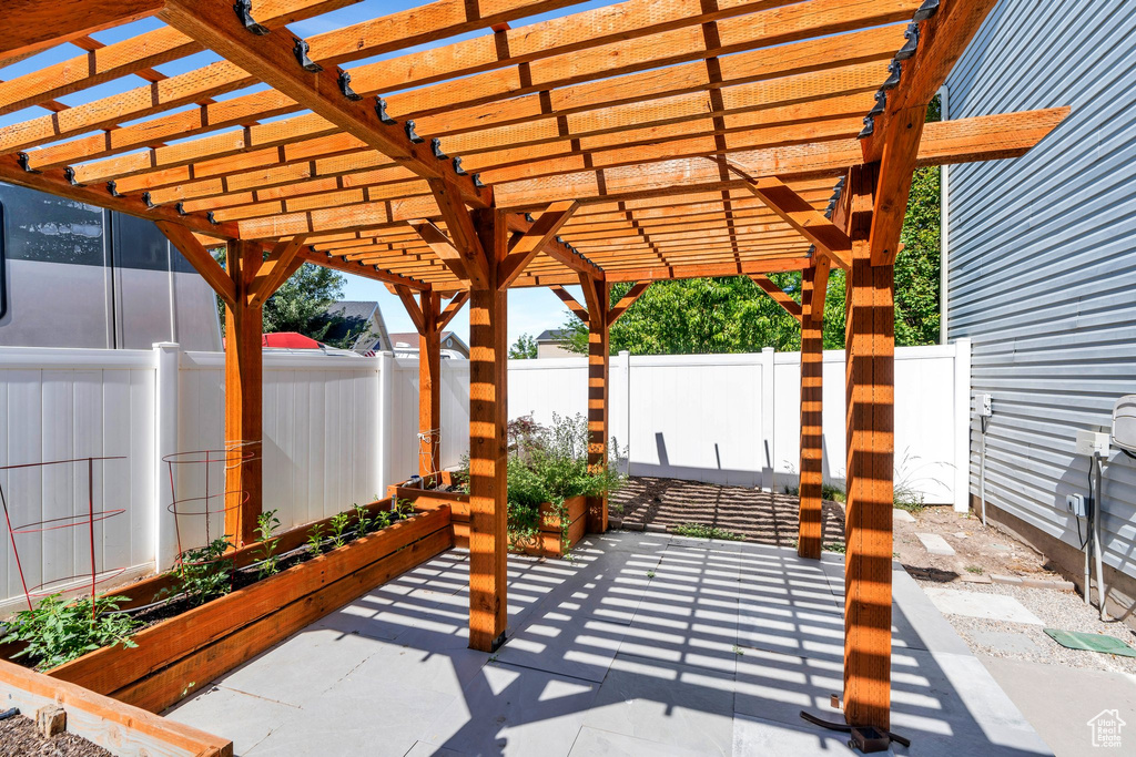 Fenced backyard with a garden, a patio, and a pergola