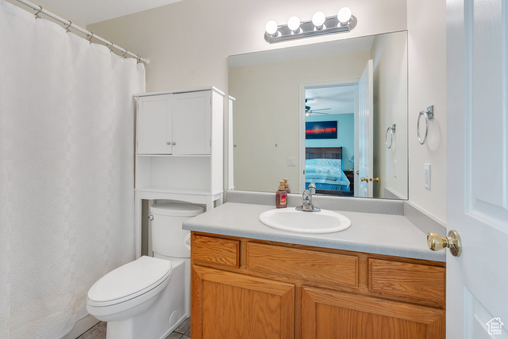 Ensuite bathroom with vanity, a ceiling fan, and curtained shower