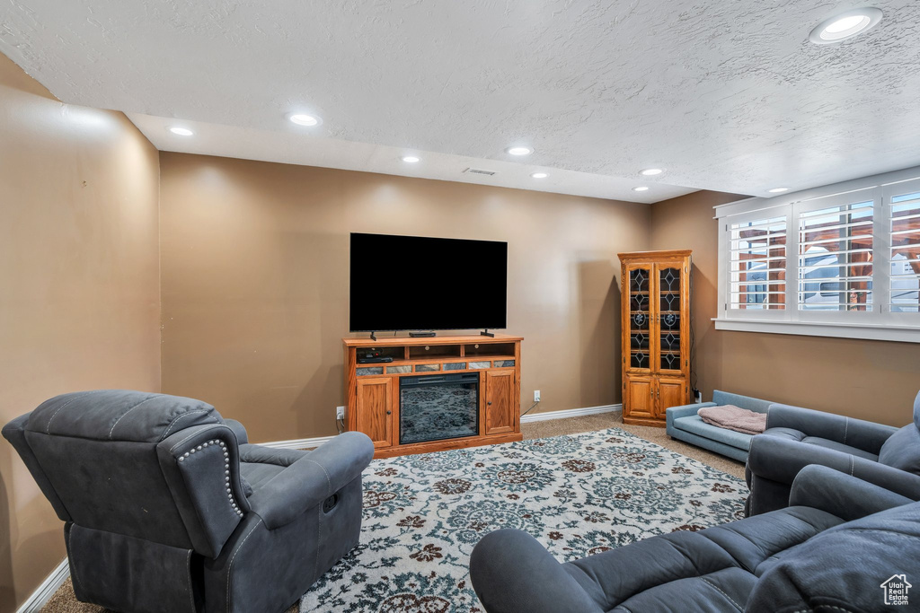 Living room featuring carpet flooring, a textured ceiling, and recessed lighting