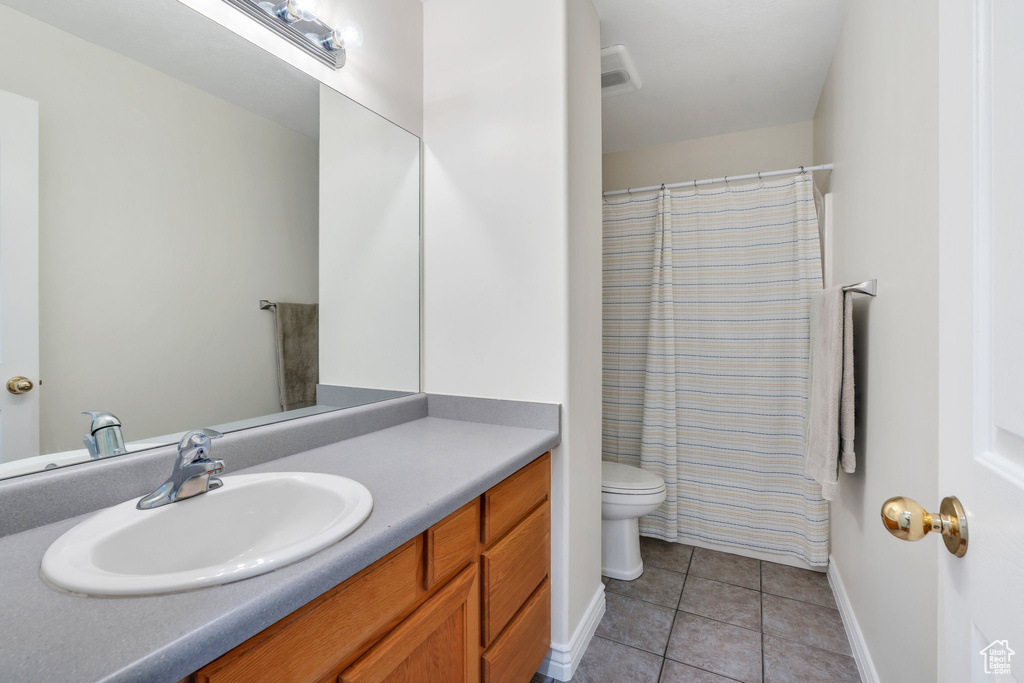 Full bath featuring tile patterned flooring, vanity, and curtained shower