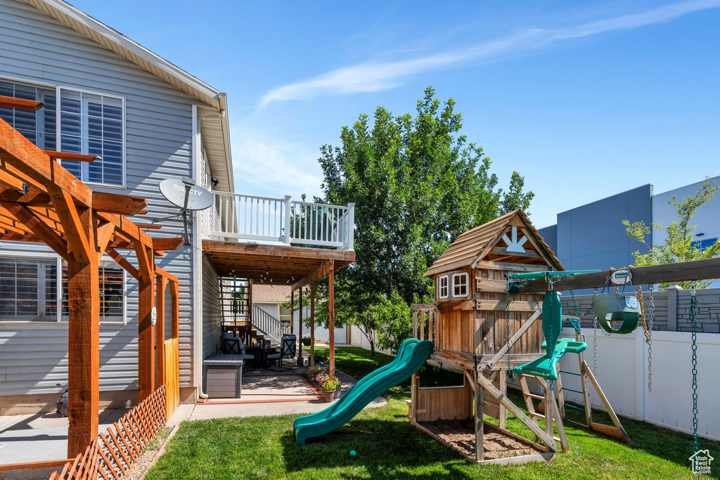 View of jungle gym featuring a fenced backyard, a patio, and a deck