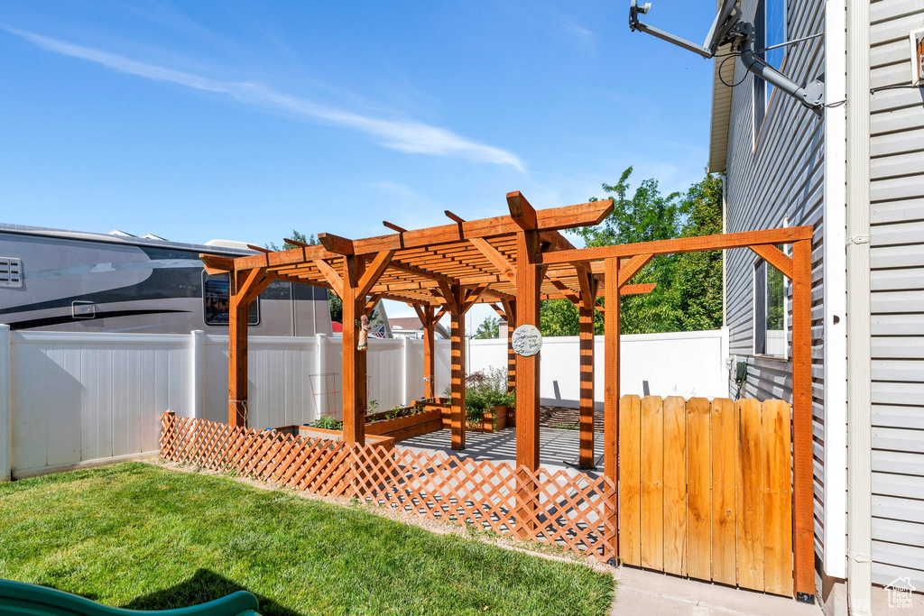 Fenced backyard featuring a pergola