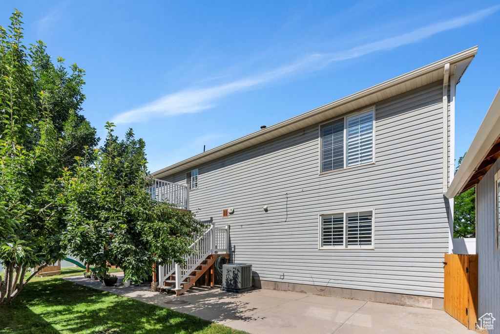 Rear view of property featuring a patio, stairway, and a lawn