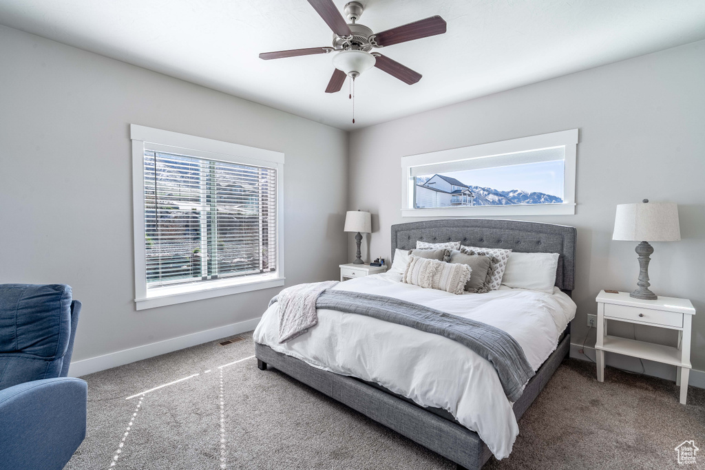 Carpeted bedroom with baseboards and a ceiling fan