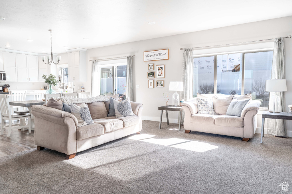 Living area featuring a chandelier, carpet flooring, and recessed lighting