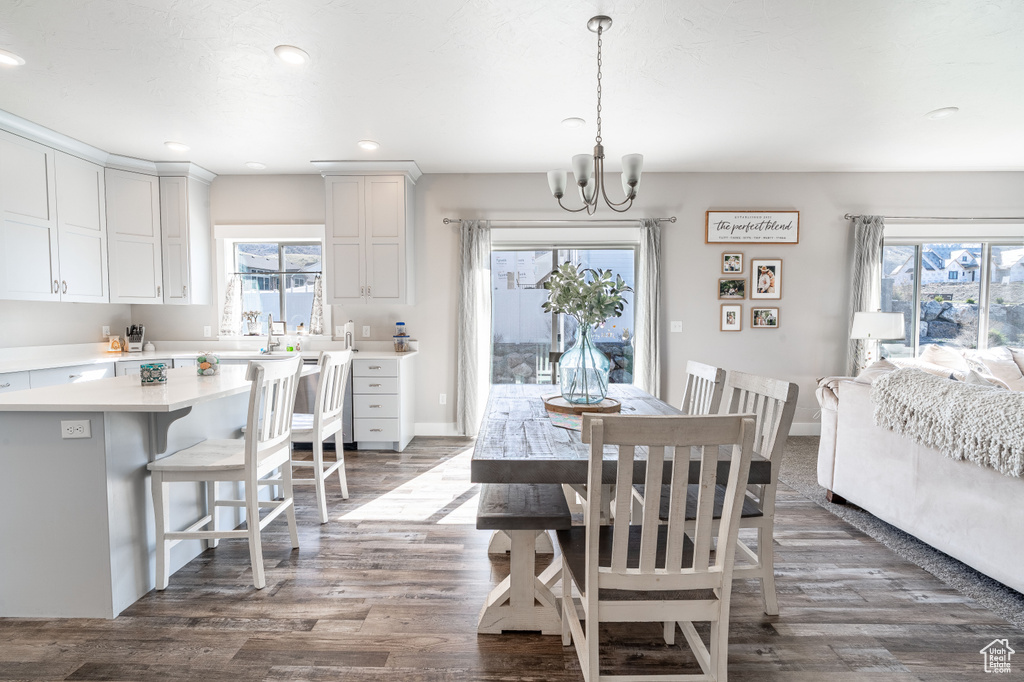 Dining room featuring a chandelier, healthy amount of natural light, dark wood-style flooring, and recessed lighting