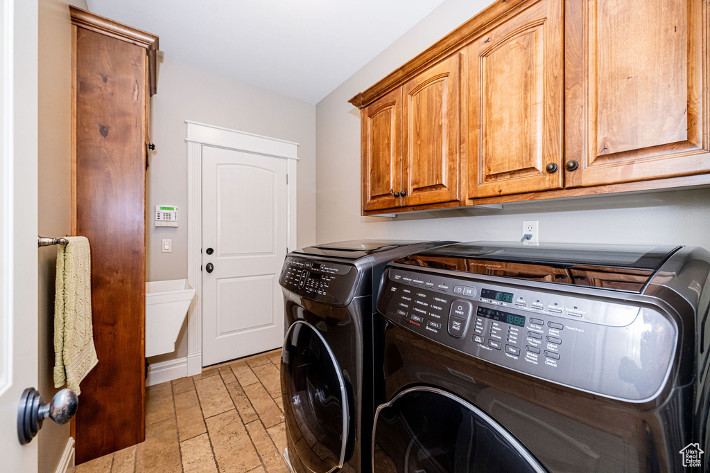 Laundry area featuring washing machine and dryer and cabinet space