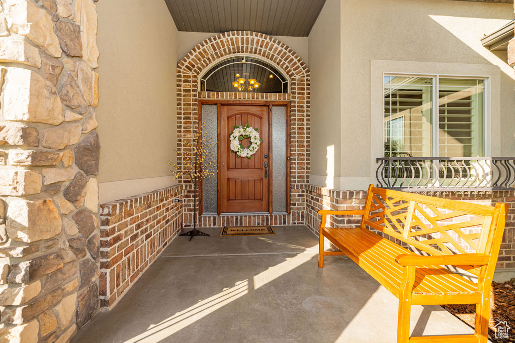 Doorway to property with stucco siding, brick siding, and stone siding