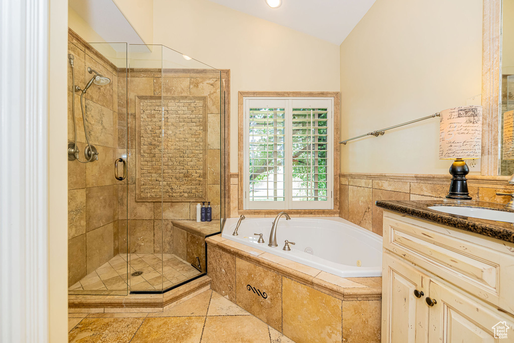 Bathroom featuring a whirlpool tub, a stall shower, vaulted ceiling, and vanity