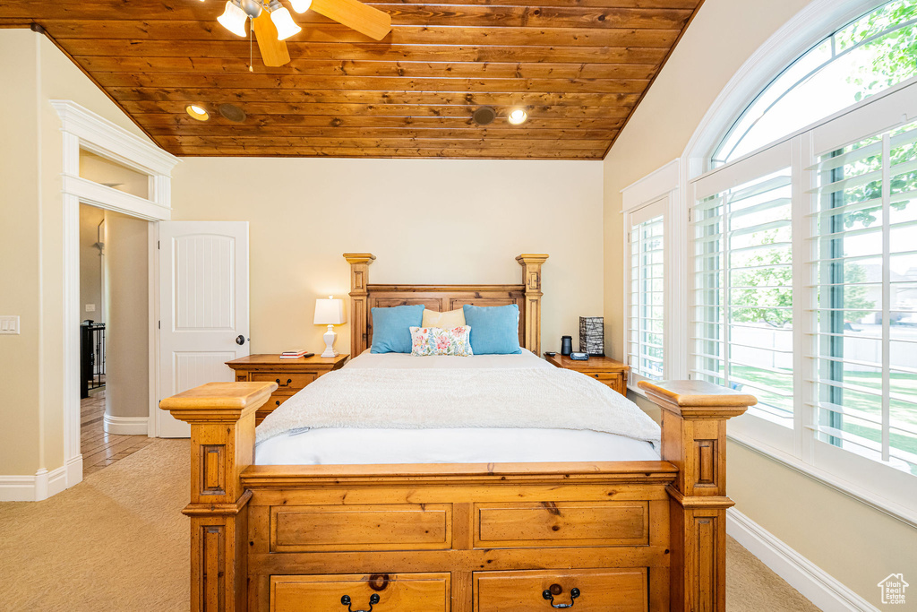 Bedroom featuring wooden ceiling, light carpet, lofted ceiling, multiple windows, and ceiling fan