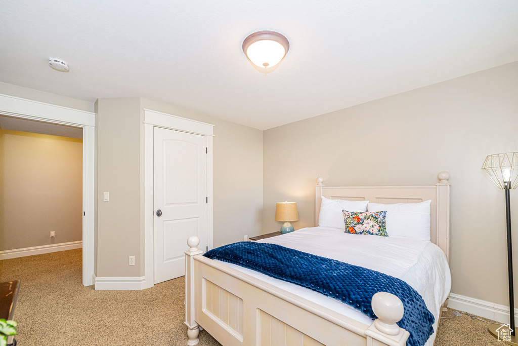 Bedroom with light colored carpet and baseboards