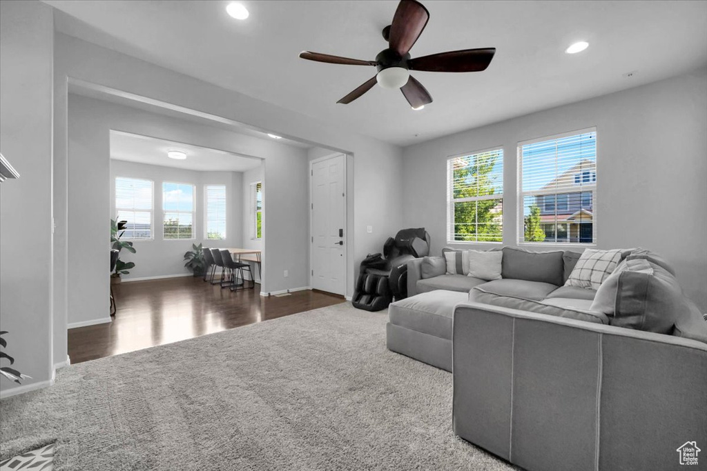 Living area with a ceiling fan, carpet floors, recessed lighting, and wood finished floors
