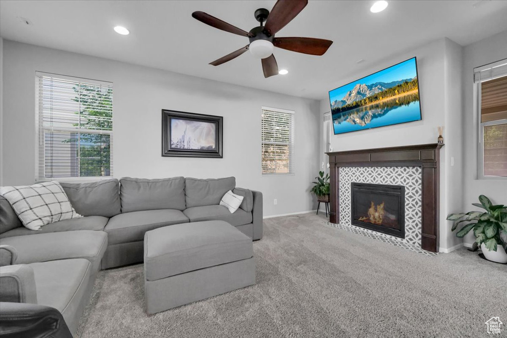 Living area with a ceiling fan, a tile fireplace, recessed lighting, carpet, and healthy amount of natural light