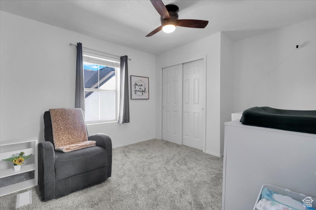 Living area with a ceiling fan and carpet