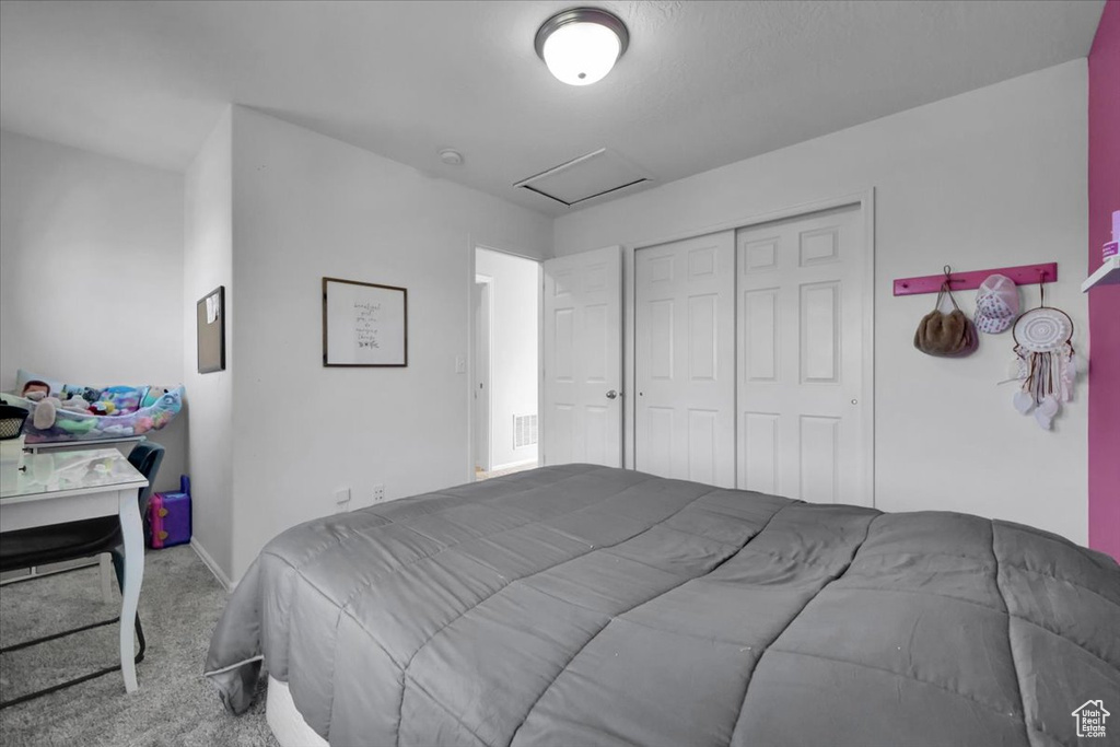 Bedroom with attic access, carpet flooring, and a closet