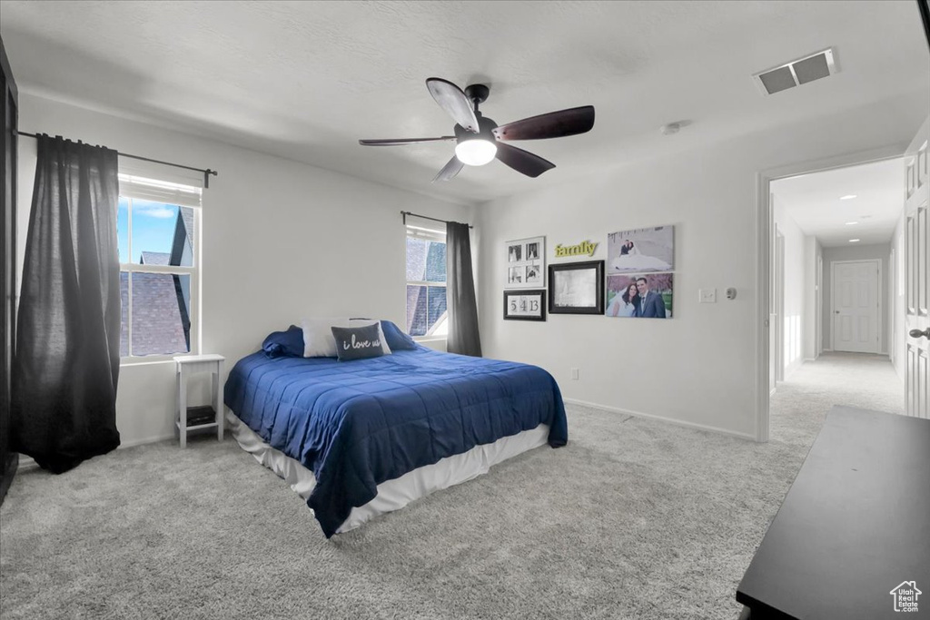 Carpeted bedroom with baseboards and a ceiling fan