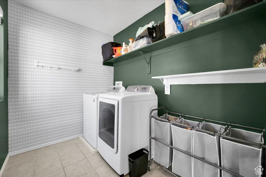 Laundry area with separate washer and dryer and light tile patterned floors