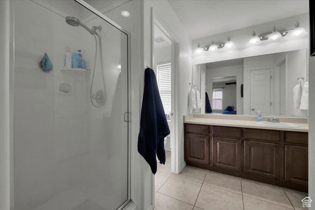 Bathroom with a stall shower, vanity, and tile patterned flooring