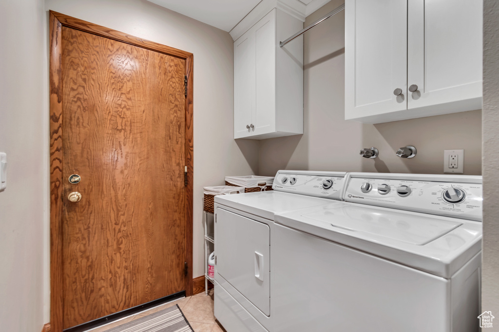 Washroom featuring washer and clothes dryer and cabinet space