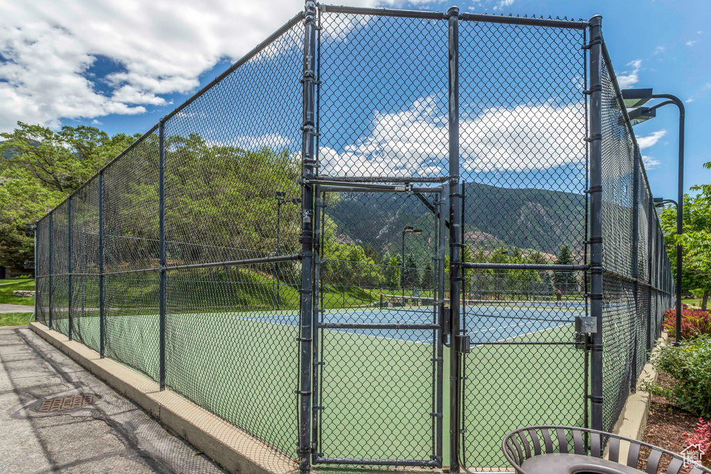 View of tennis court featuring a gate