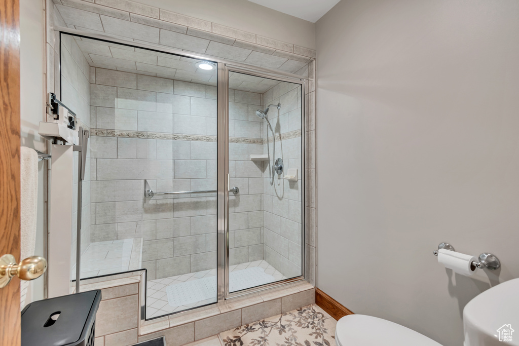 Bathroom featuring toilet and a stall shower