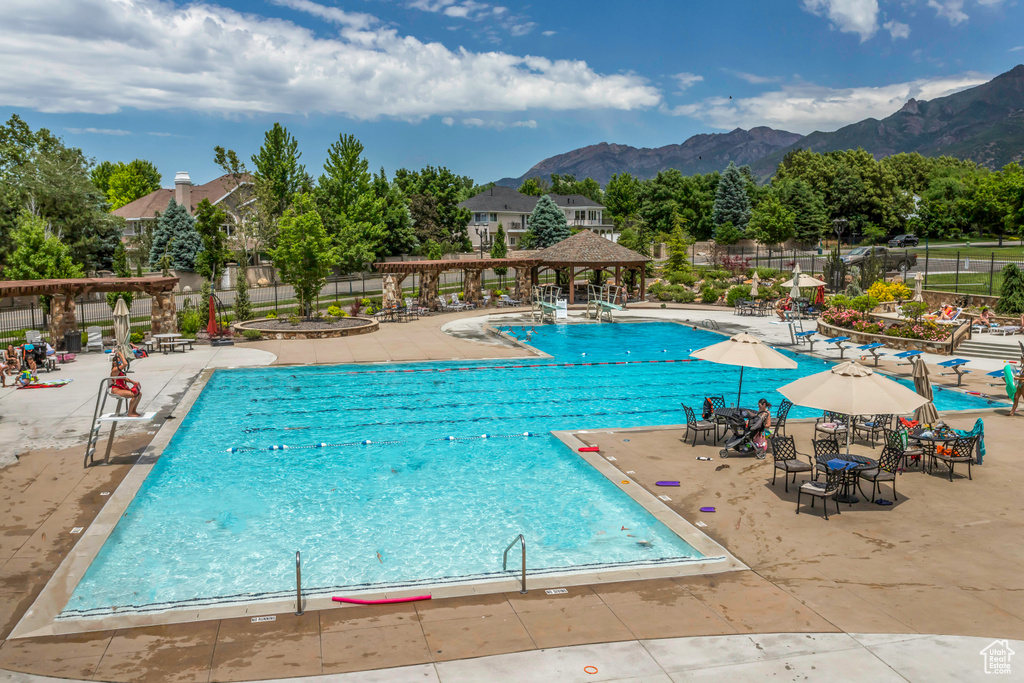 Community pool featuring a mountain view, a pergola, and a patio