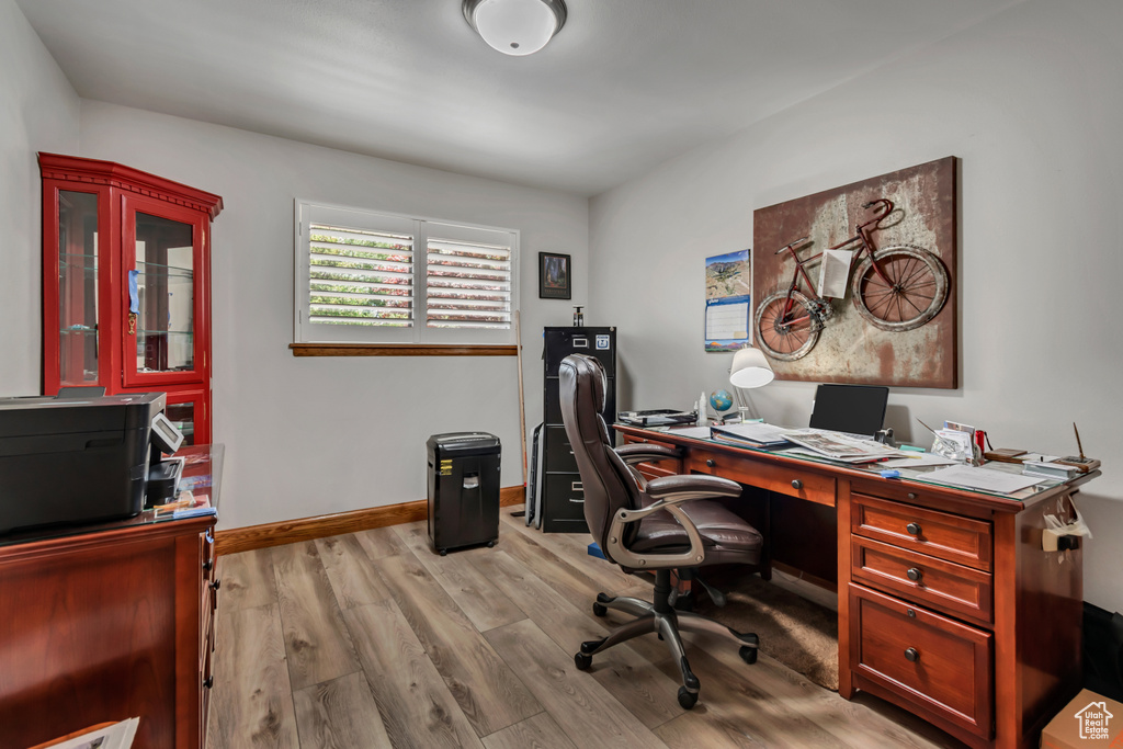Office area with light wood-style floors and baseboards