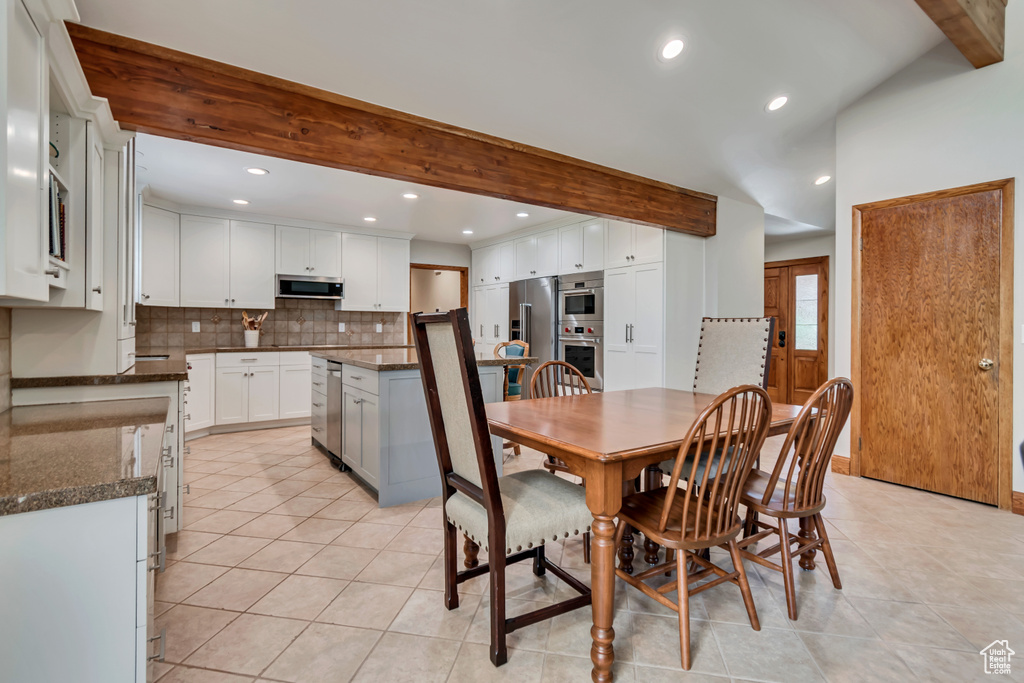 Dining area featuring beam ceiling, light tile patterned flooring, and recessed lighting