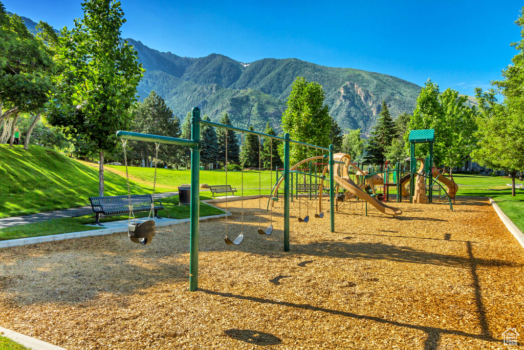 Community playground with a mountain view and a yard