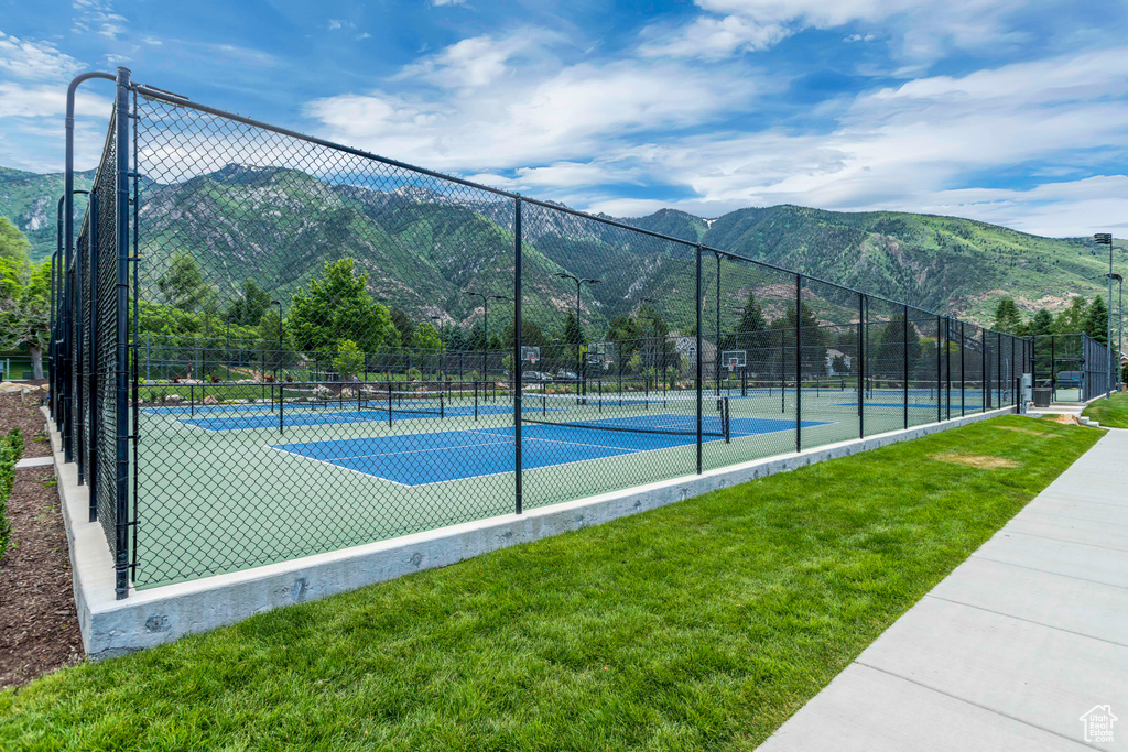 View of sport court with a tennis court and a mountain view