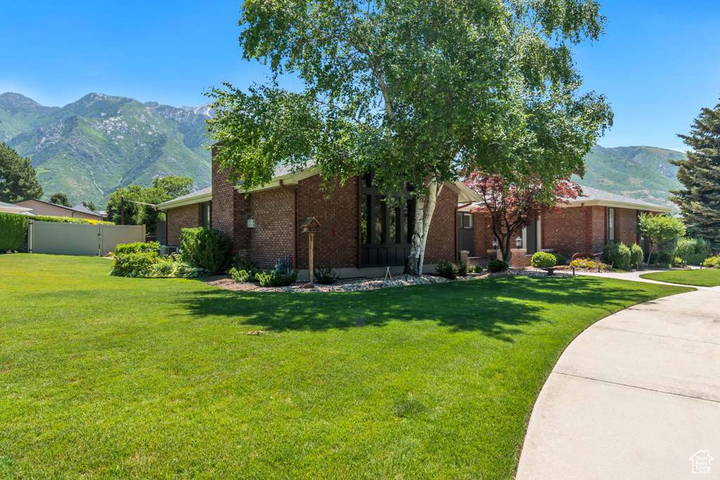 View of home\\\\\\\'s exterior with brick siding, a mountain view, and a chimney