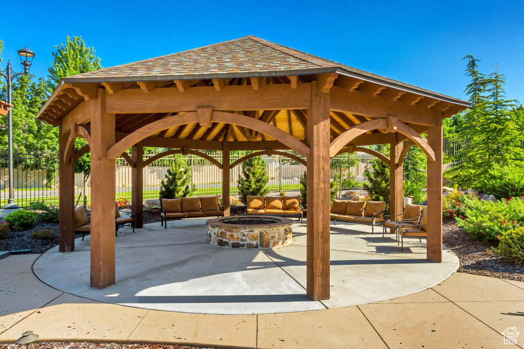 View of property\'s community with a gazebo, a patio, and an outdoor living space with a fire pit