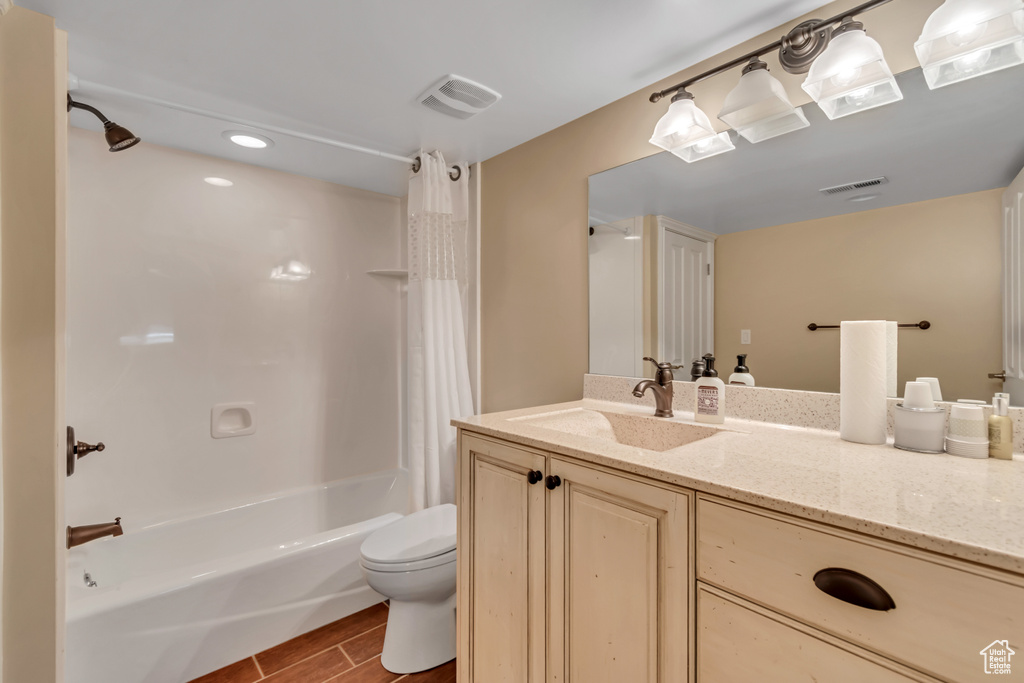 Full bath with vanity, shower / bath combo, and wood finished floors