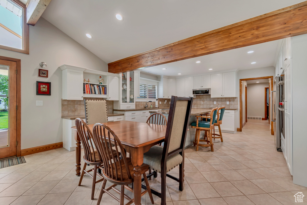 Dining space with light tile patterned flooring and recessed lighting