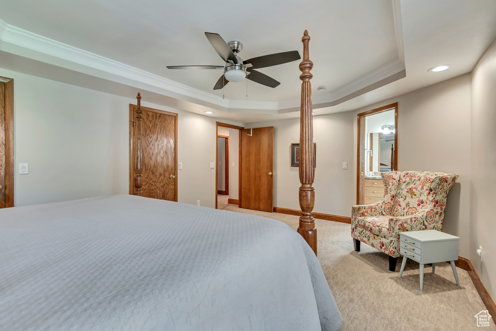 Carpeted bedroom featuring a raised ceiling, crown molding, recessed lighting, and ceiling fan